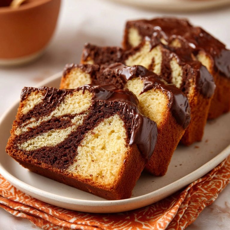 Saftiger Marmorkuchen mit Schokoglasur in Nahaufnahme: Die perfekte Marmorierung und cremige Schokoglasur machen diesen Kuchen unwiderstehlich.