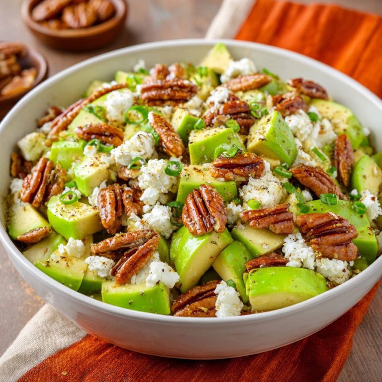 Frischer Apfel-Avocado-Pecan-Salat mit knackigen Pekannüssen und cremigem Ziegenkäse in einer Nahaufnahme serviert.