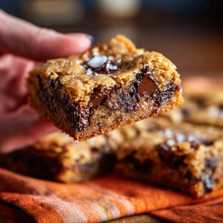 Meine unwiderstehlichen Chocolate Chip Bars: Nahaufnahme eines saftigen Stücks mit geschmolzener Schokolade und grobem Meersalz, serviert.