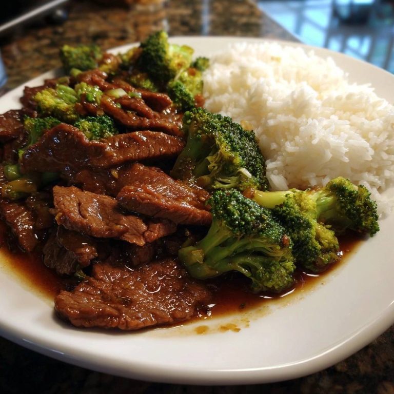 Asiatisches Rindfleisch mit Brokkoli auf einem Teller serviert, mit Reis und Brokkoli-Röschen, appetitlich angerichtet.