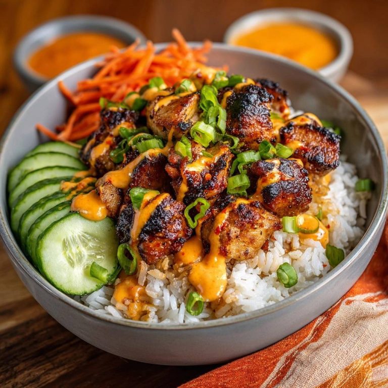 Knusprige Gochujang-Hähnchen-Bowl serviert in einer Schüssel, mit Gurken, Karotten und Frühlingszwiebeln garniert und mit Sauce beträufelt.