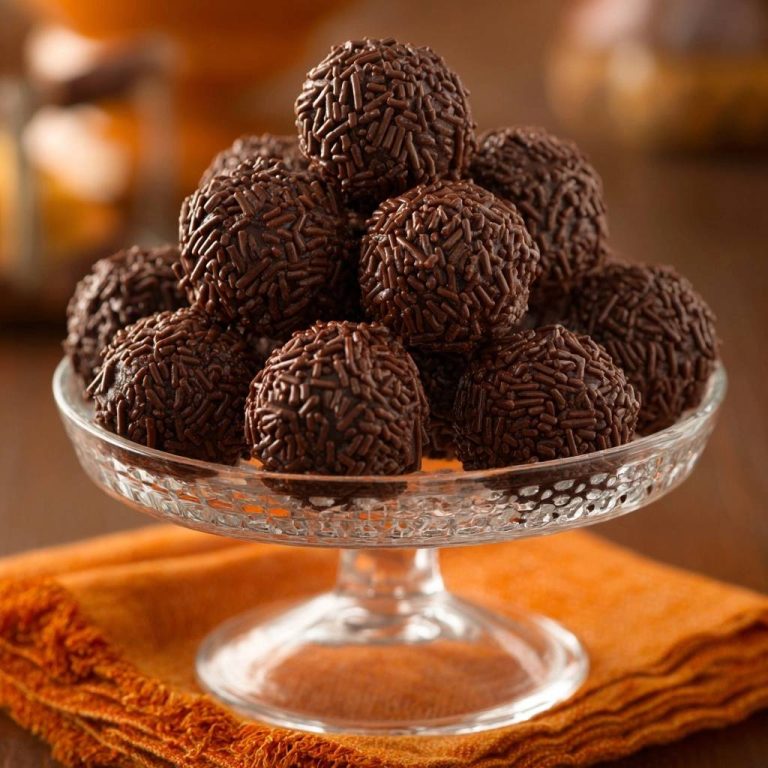 Brasilianische Brigadeiros liegen auf einem eleganten Servierteller, bedeckt mit Schokostreuseln. Eine köstliche Süßspeise, perfekt für jeden Anlass.