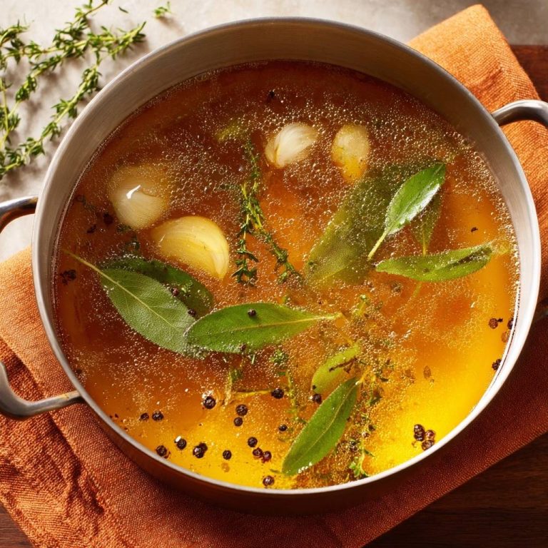 Goldene Aromen-Bouillon, eine aromatische Brühe, die von oben in einer Pfanne mit Knoblauch, Kräutern und Gewürzen zubereitet wird.