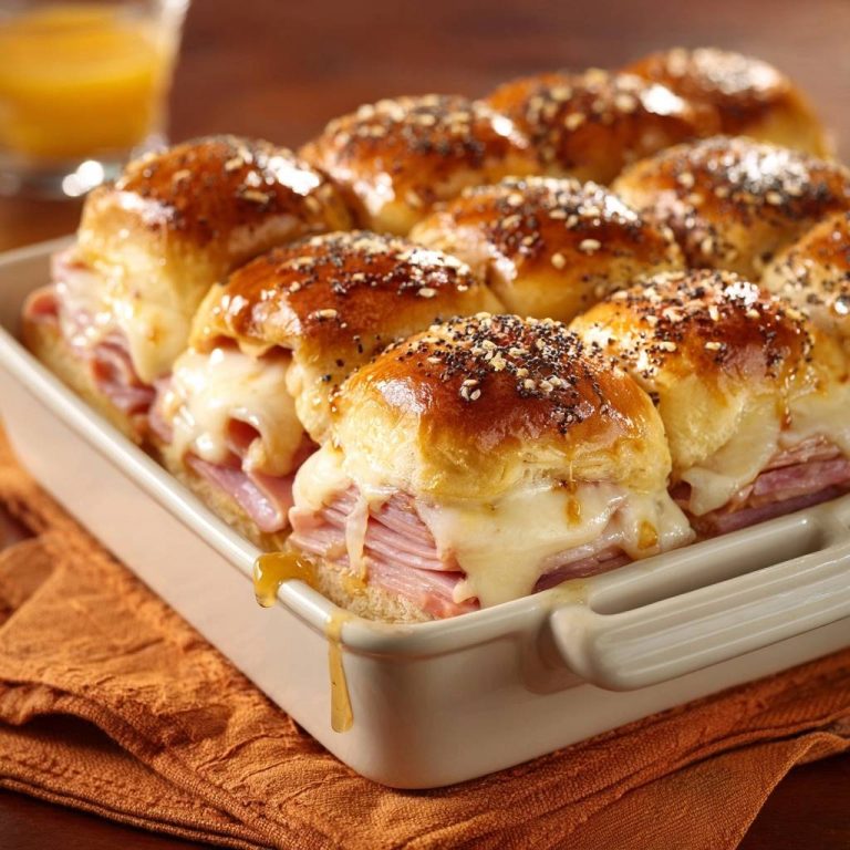Herzhafte Schinken-Käse-Slider mit geschmolzenem Käse, abgebildet in einer Nahaufnahme, die die saftige Füllung zeigt.