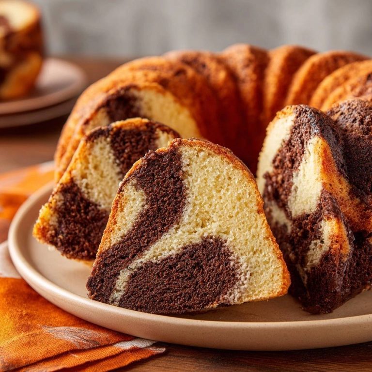 Klassischer Marmorkuchen, frisch angeschnitten und serviert, zeigt eine detailreiche Innenansicht mit kontrastreichen Schichten.