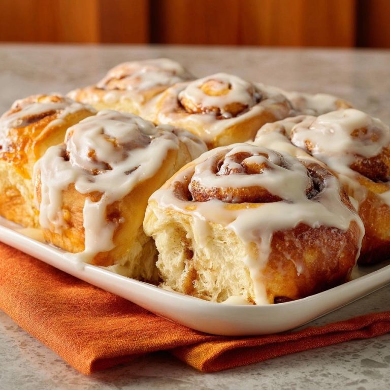 Zimtschnecken, frisch gebacken und mit Glasur bedeckt, zeigen eine Nahaufnahme des weichen Inneren und der köstlichen Zimtschnecken.