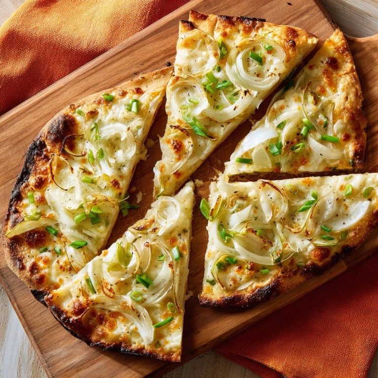 Knuspriges Zwiebel-Flatbread, von oben aufgenommen, zeigt die knusprige Kruste und die großzügige Zwiebelbelegung in saftigen Dreiecken.